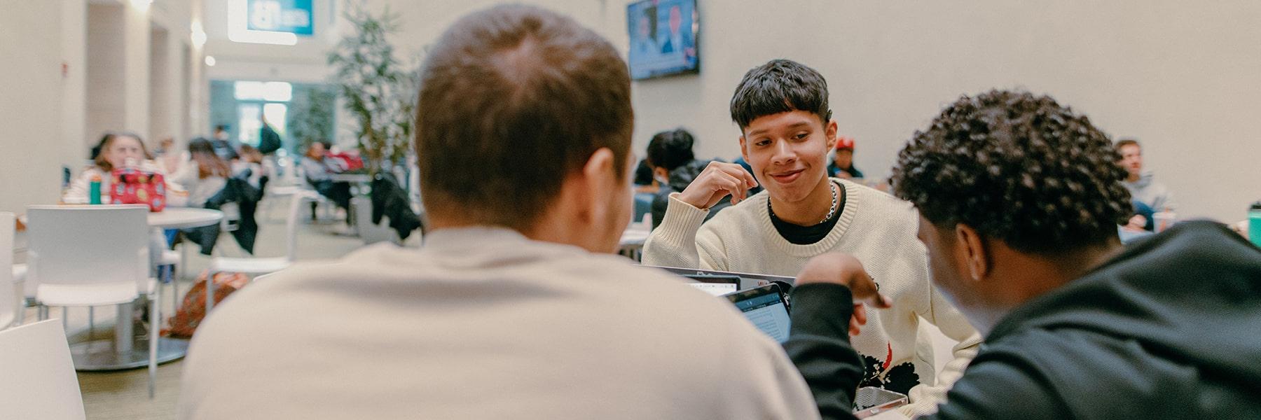 Three students study at table together in Campus Center.