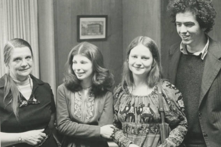 A black and white photo of four students posing and smiling